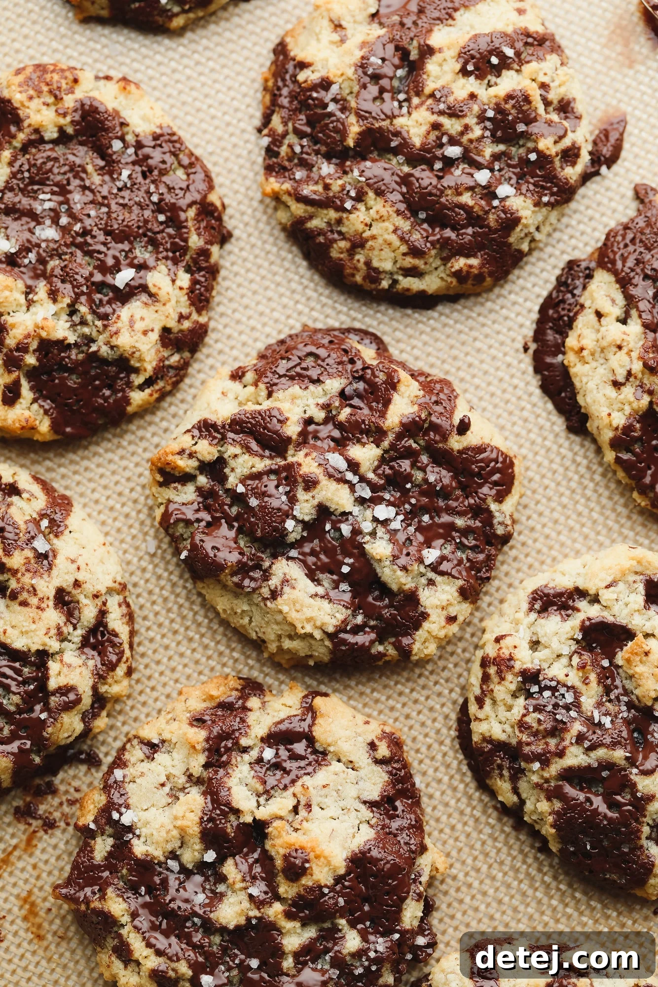 close up on baked almond flour cookies on a lined baking sheet.
