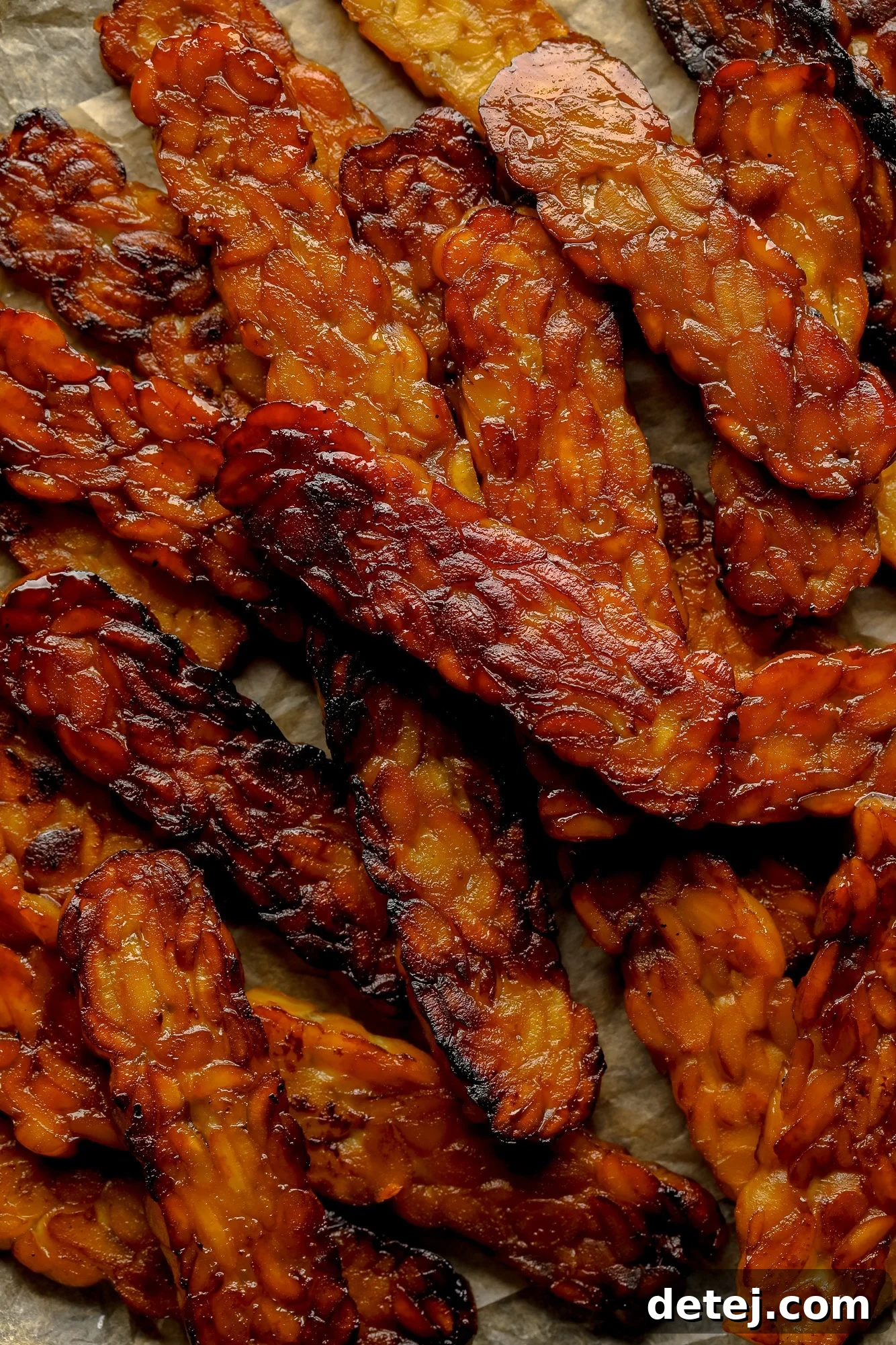 A generous pile of freshly pan-fried tempeh bacon slices, garnished and ready for a meal.