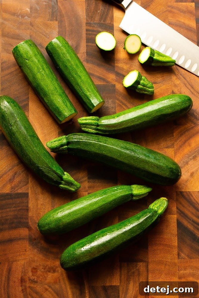 A bounty of fresh green zucchinis resting on a wooden cutting board, ready for preparation.