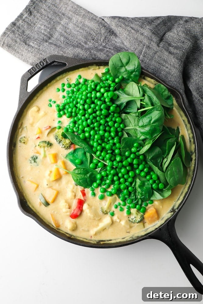 Vibrant Vegan Thai Green Curry 6 creamy sauce with vegetables in a pan with peas and spinach