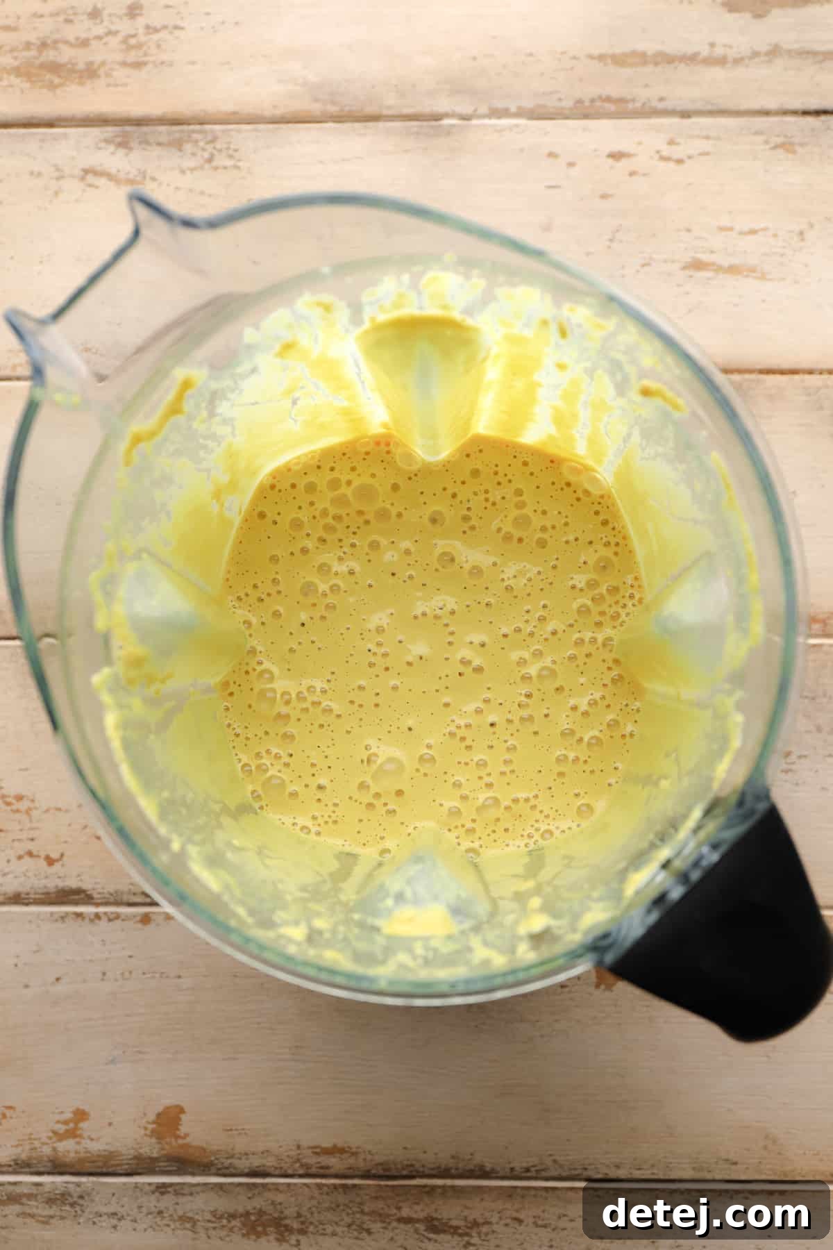 yellow sauce in Vitamix on wooden background