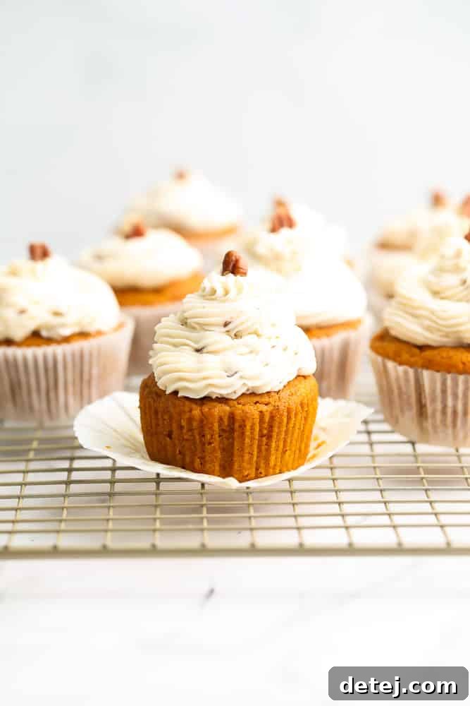 lots of pumpkin cupcakes with pecan pieces on top