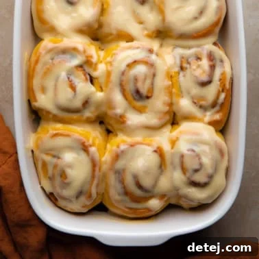 square image of vegan pumpkin cinnamon rolls in a dish