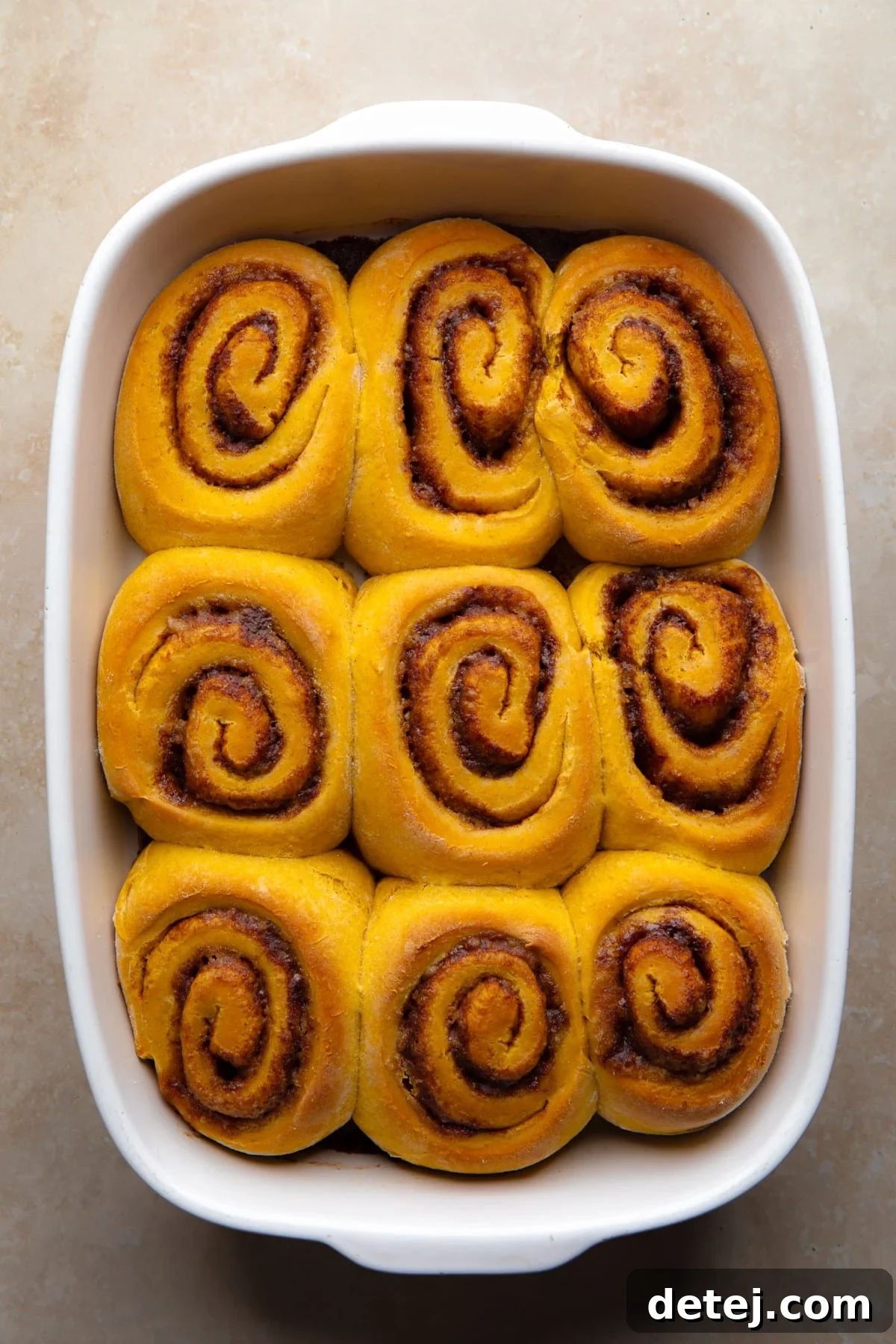 orange colored vegan pumpkin cinnamon rolls