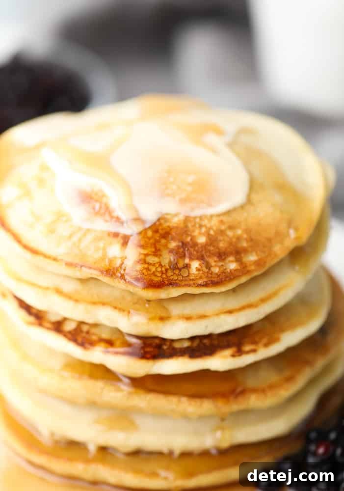 Close-up of a stack of fluffy vegan buckwheat pancakes with a pat of vegan butter melting on top, ready to be enjoyed.