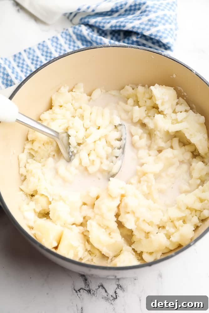 mashing potatoes in pot