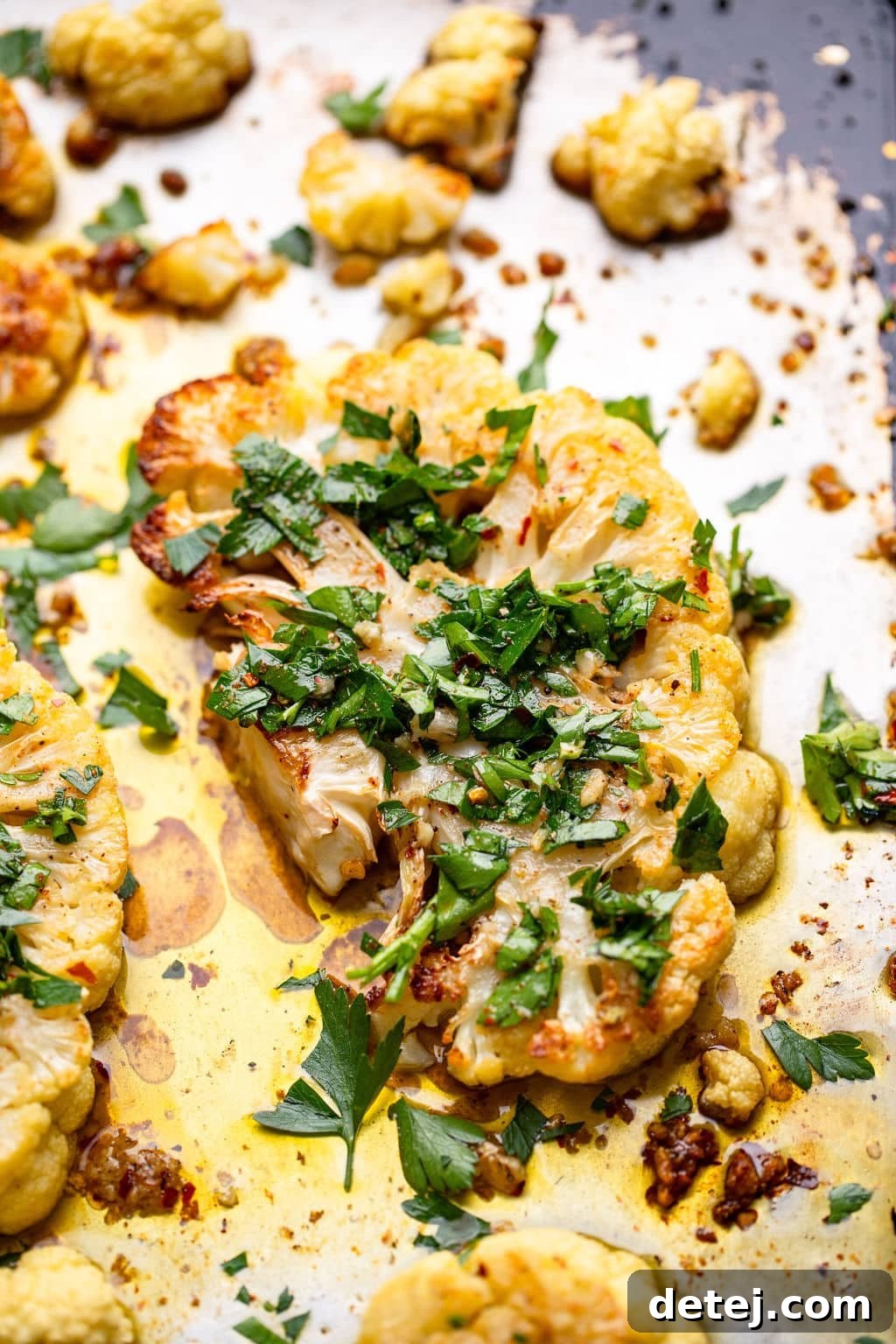 roasted cauliflower on a baking sheet with herbs
