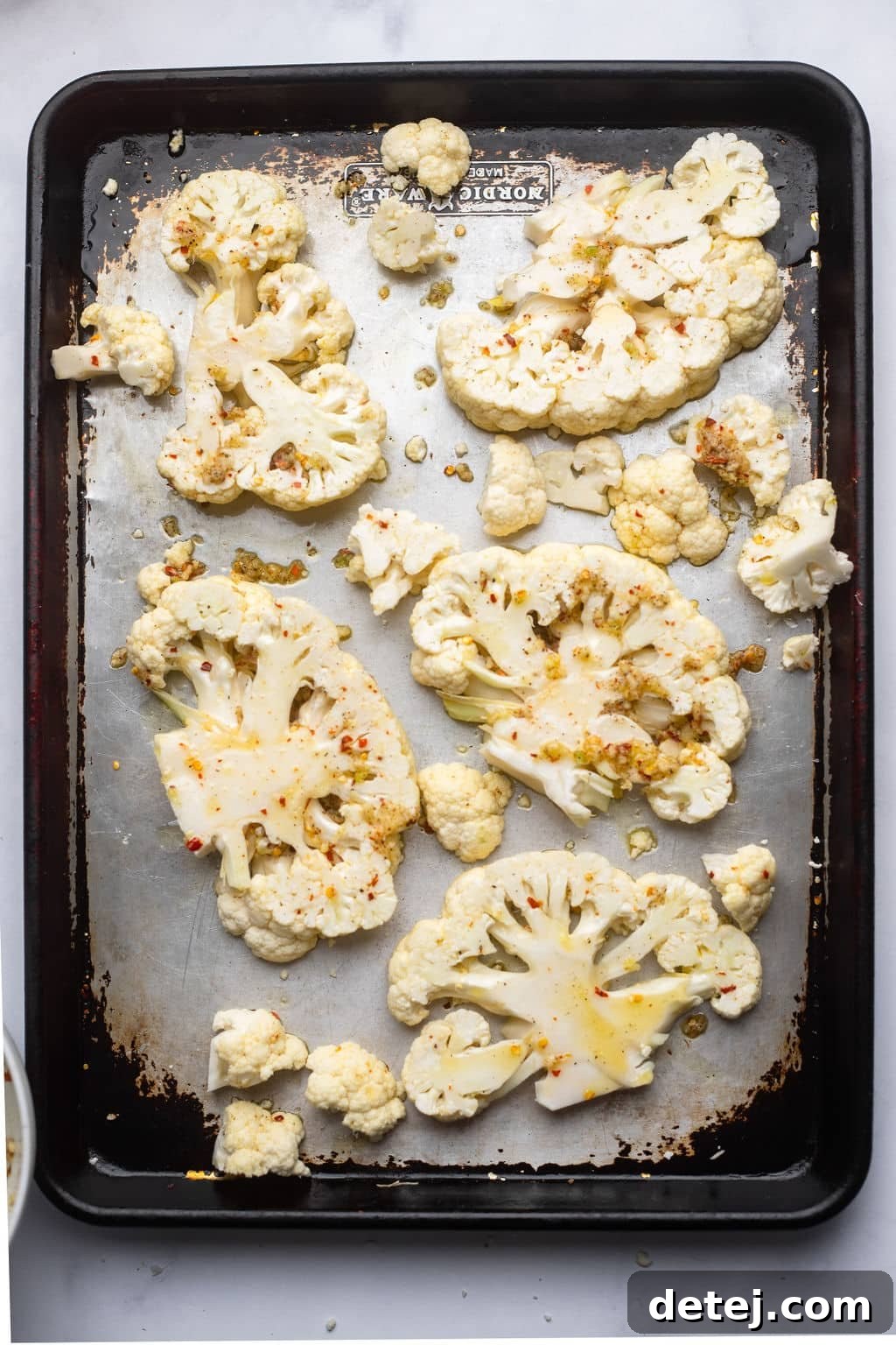 5 cauliflower steaks on a baking sheet ready to bake