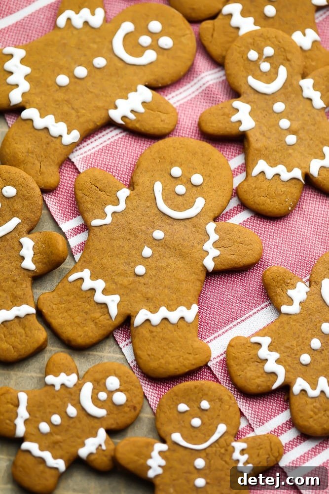 A vibrant display of iced vegan gingerbread people, set against a cozy red towel background, ready for festive celebrations.