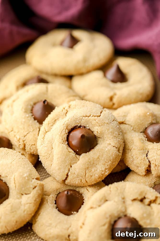 A beautiful spread of freshly baked vegan peanut butter blossoms with a purple towel in the background, showcasing their festive appeal.
