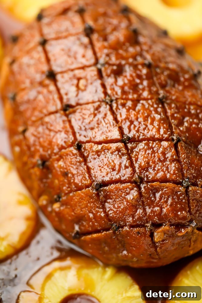A close-up view of the scored seitan roast, adorned with whole cloves and glistening with a rich maple glaze, showcasing its festive appeal.