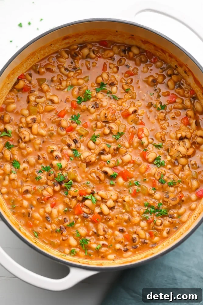 A large white pot filled with cooked Southern black eyed peas, ready to be served.