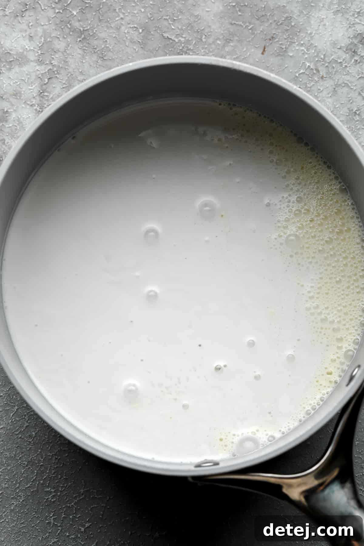 Plant milk heating in a saucepan, the foundation for our creamy vegan custard.
