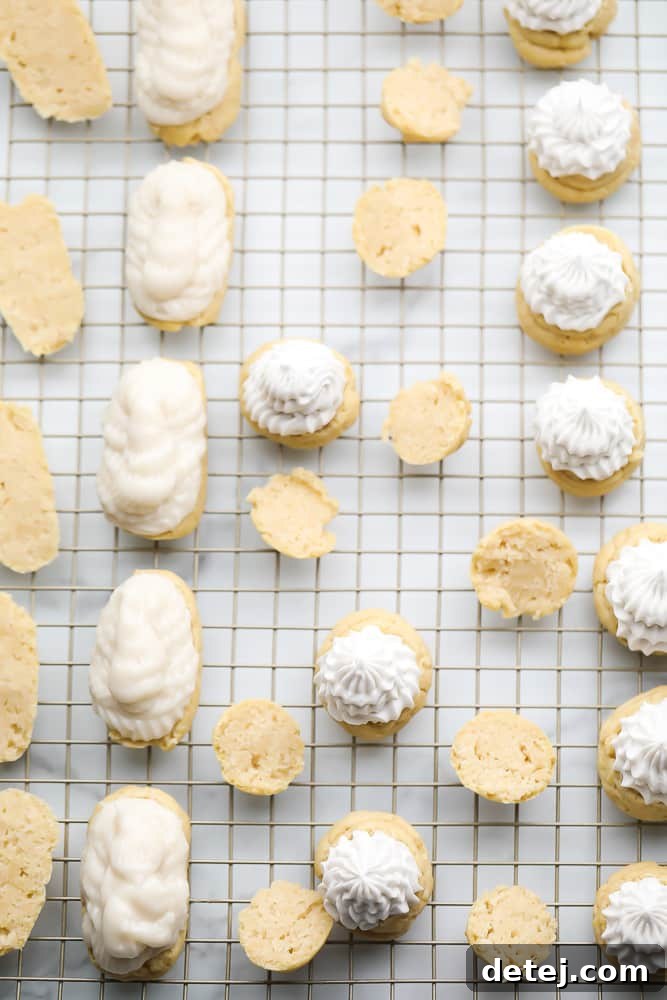 Cooked choux pastry shells, some filled with whipped cream and others with custard and chocolate, ready to be enjoyed.