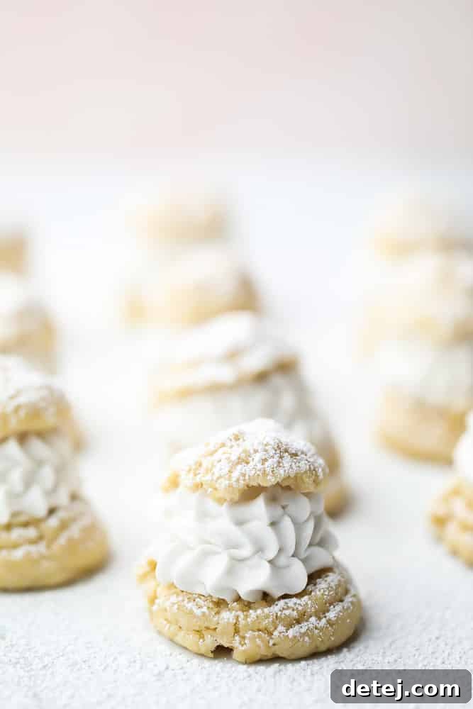 A close-up shot of a vegan cream puff filled with coconut whipped cream, set against a soft pink background.