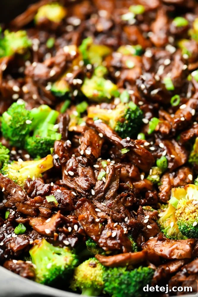 Close-up view of rehydrated soy curls and tender broccoli florets simmering in a savory sauce in a pan
