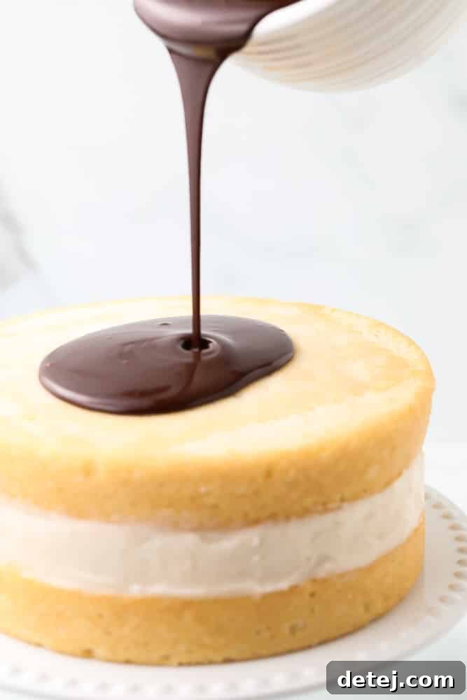 Rich chocolate ganache being skillfully poured over the top layer of a Vegan Boston Cream Pie, creating a smooth, glossy coating.