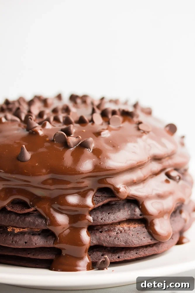 stack of chocolate pancakes with ganache and chocolate chips