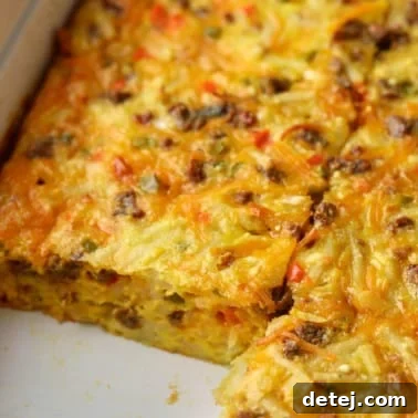 A close up on a sliced Vegan Breakfast Casserole in a baking dish, showcasing its perfect layers.
