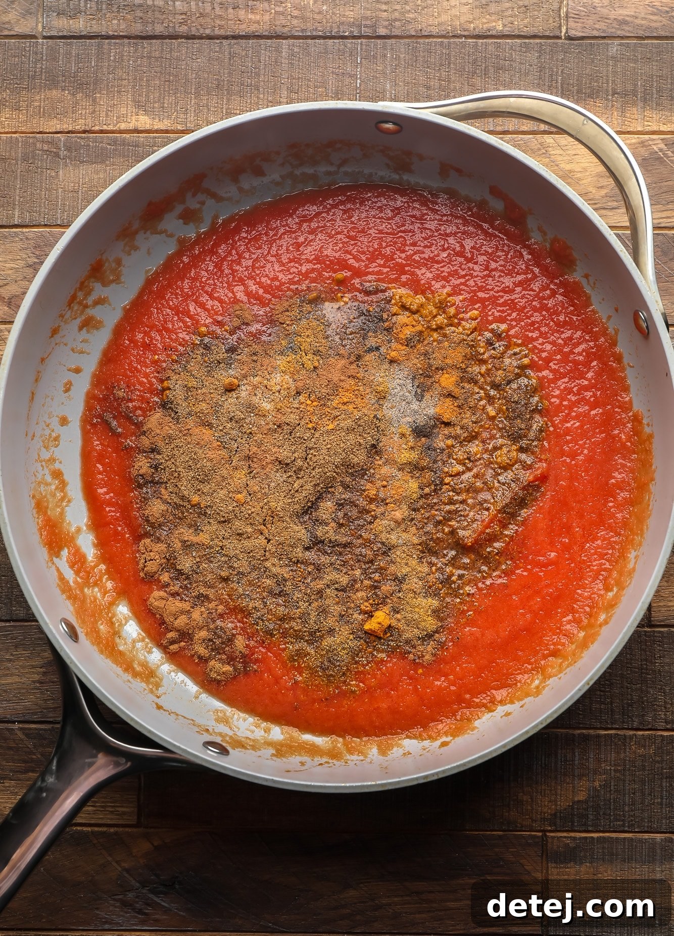 Indian spices and tomato sauce in a large skillet.