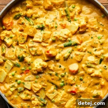 close up on a large pot of golden vegetable korma.