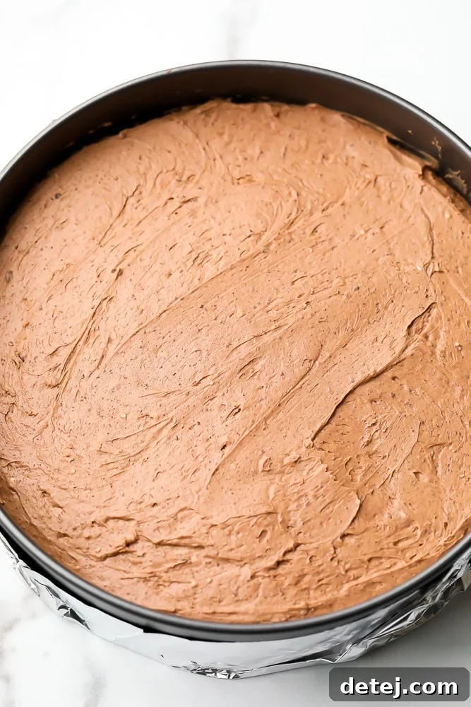 Raw chocolate cheesecake filling in a metal pan
