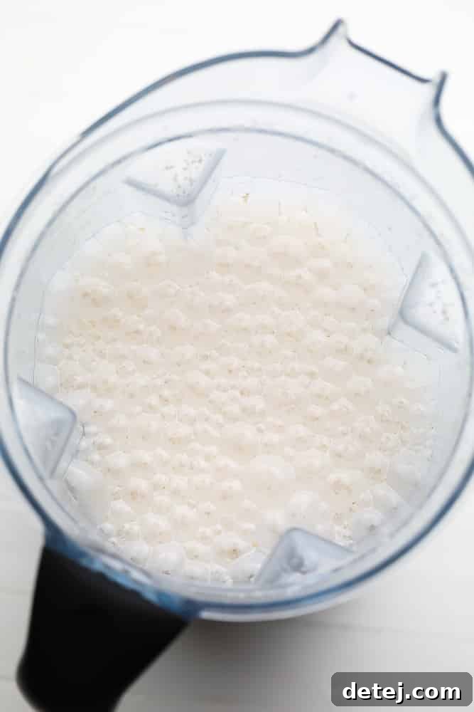 Blended creamy white mixture in a blender, ready for straining.