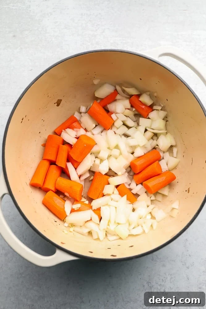 Large pot with raw onions and carrots
