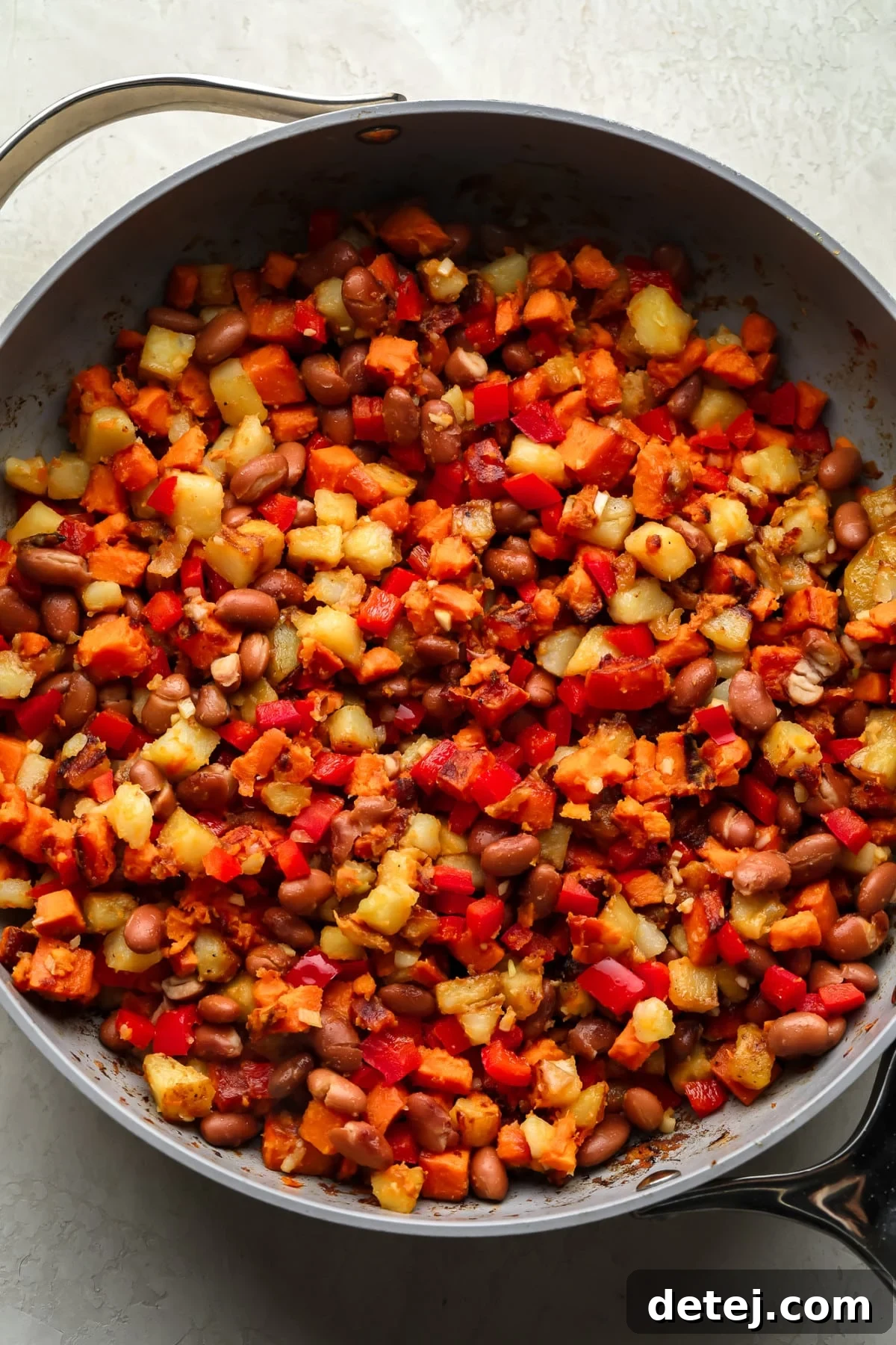 breakfast hash in pan with sweet and regular potatoes, red pepper and beans