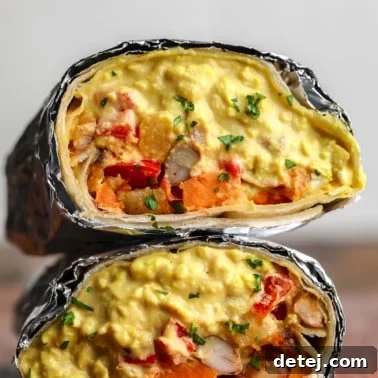 square image of a close up vegan breakfast burrito with eggy mixture and potato veggies