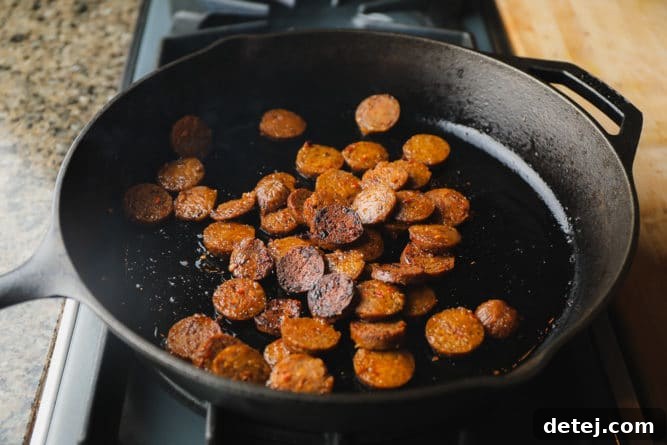 sausage cooking in a cast iron pan