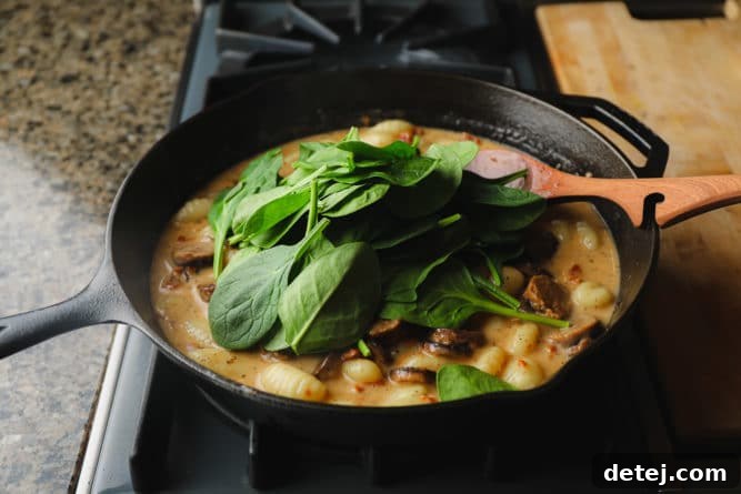 spinach added to a pan with gnocchi