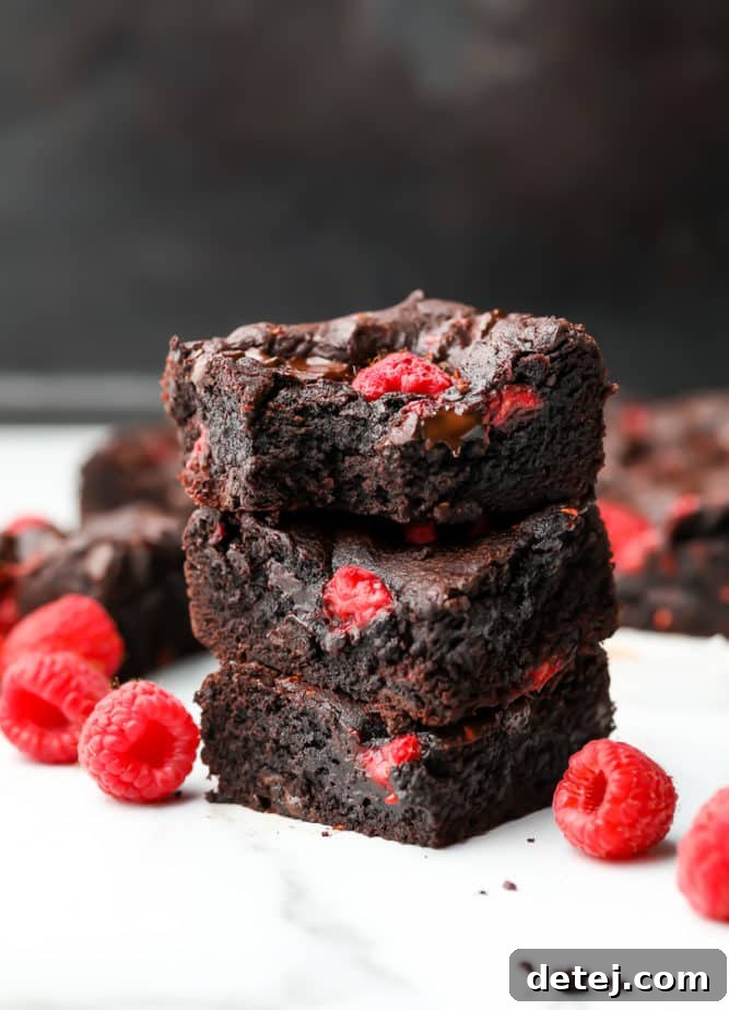 stack of 3 brownies with berries in them and around them