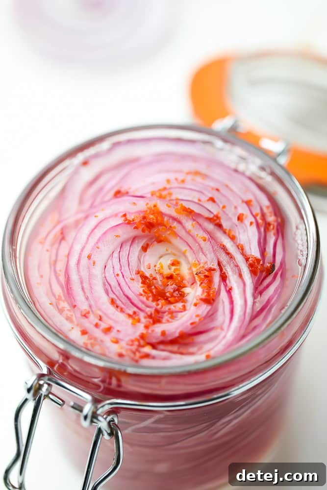 Tangy Ruby Onions 4 close up of sliced red onions in a mason jar with red flakes on top
