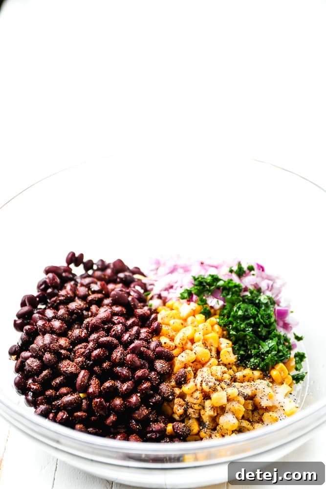 black beans, corn, herbs, and onions in a glass bowl