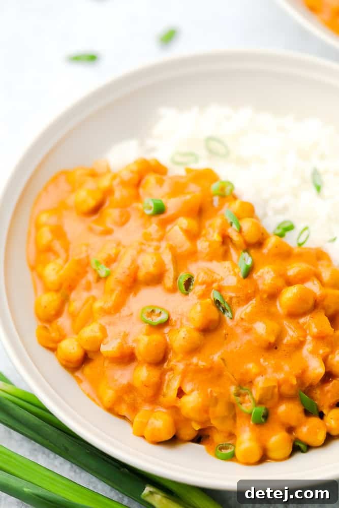 close up up bowl with beans in orange curry sauce and rice