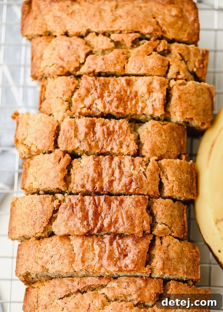 An overhead view of a freshly baked, sliced loaf of gluten-free vegan banana bread, ready to be served.