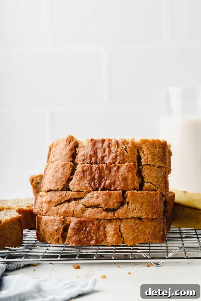 Several golden-brown slices of gluten-free vegan banana bread cooling on a wire rack.