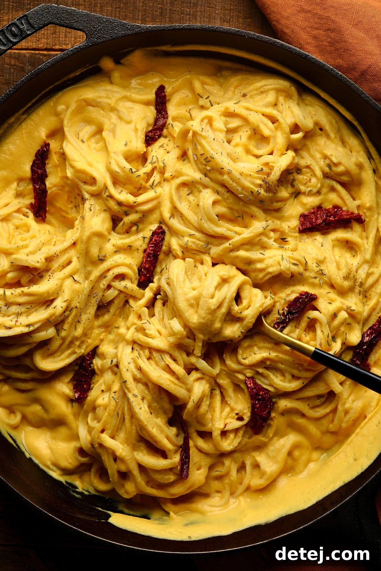 Velvety Butternut Pasta Sauce 2 cast iron filled with long noodles with lots of butternut squash pasta sauce and sun dried tomatoes