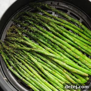 close up of cooked asparagus in an air fryer basket