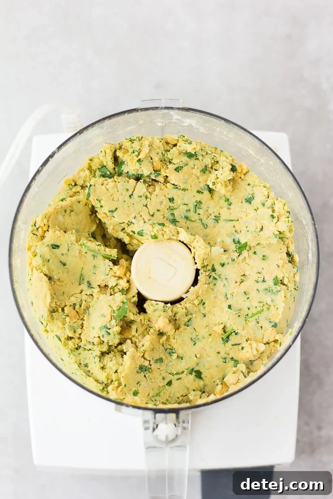 Blended vegan falafel mixture in a food processor, showing the ideal crumbly texture