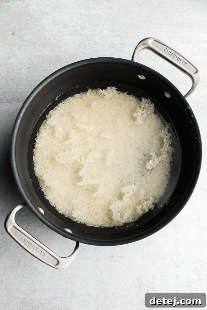 White Basmati rice and water combined in a black pot, demonstrating the start of the cooking process.