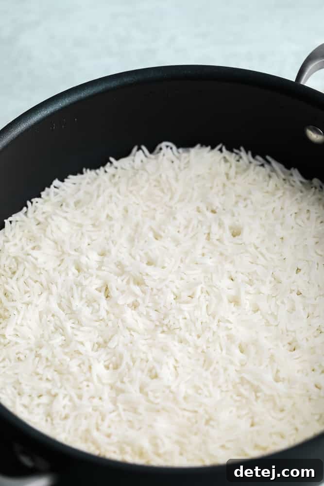 Close-up view of a black pot filled with beautifully cooked white Basmati rice, showcasing its inviting texture.