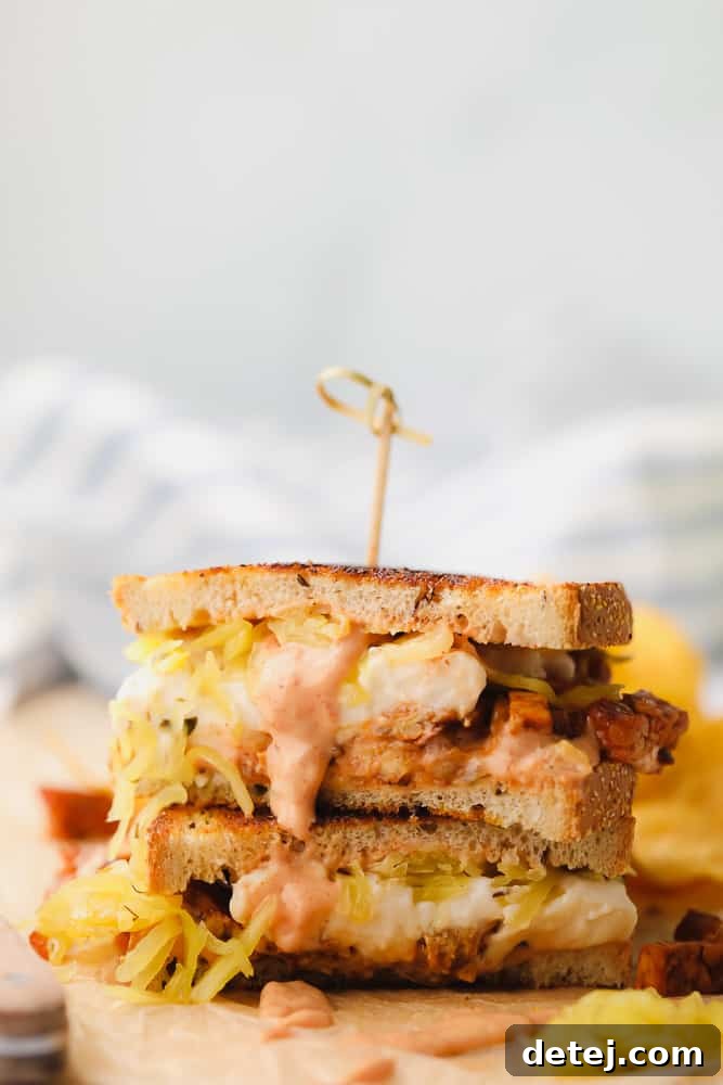 vegan reuben sandwich sliced in half with sauerkraut and russian dressing leaking out