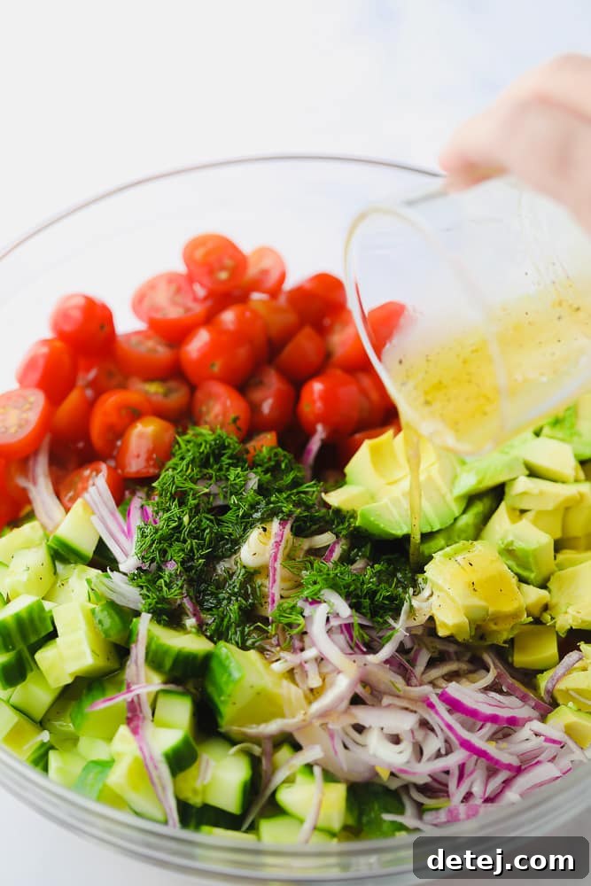 Lemon dressing being poured over a colorful bowl of chopped vegetables, promising a zesty addition to the salad.