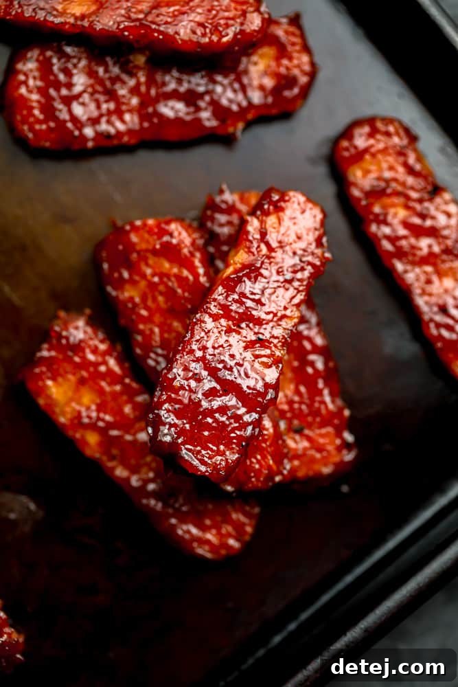 Cooked sticky BBQ tempeh ribs arranged on a pan