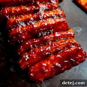 square image of lined up tempeh ribs with bbq sauce