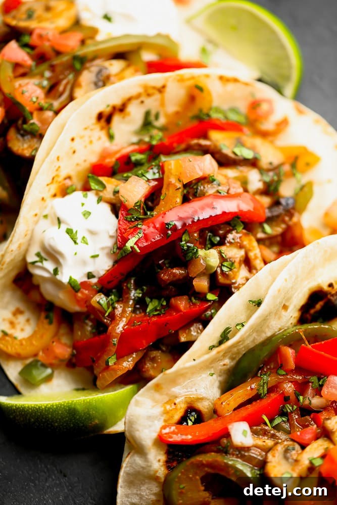 Close-up view of a warm tortilla generously stuffed with perfectly cooked red bell peppers and onions, showcasing the vibrant colors and tender texture of the fajita filling.