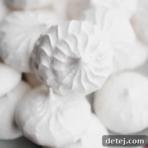 Close up on a pile of white vegan meringues cookies on a small grey plate