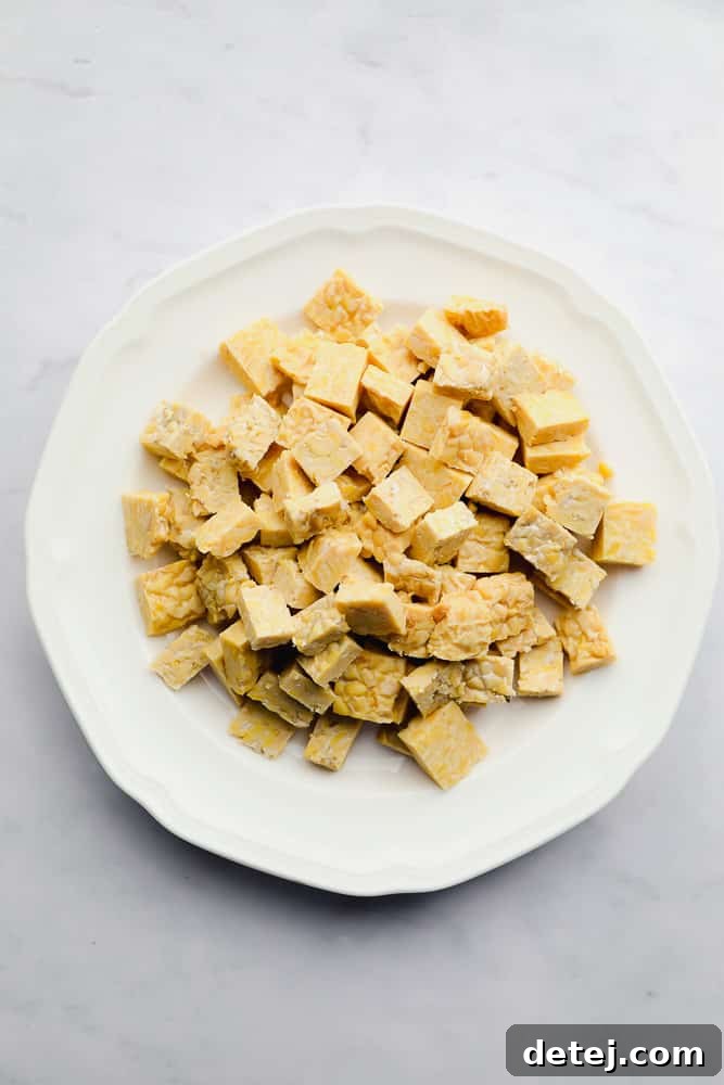 cubes of beige tempeh on a white plate